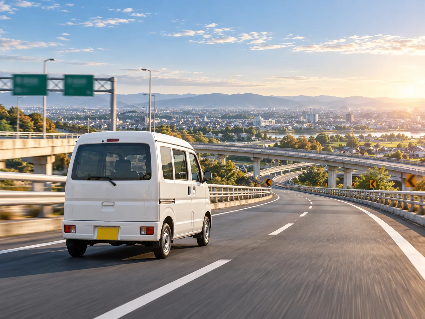 高速道路を遠くの街へ向かって走る軽バン